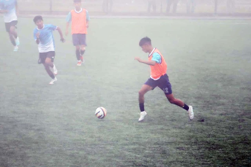 Players of Auyang FC and Yungyangkhu FC (orange bibs) in action on a foggy Friday at Loyem Memorial Astro Turf, Tuensang. (Morung photo)